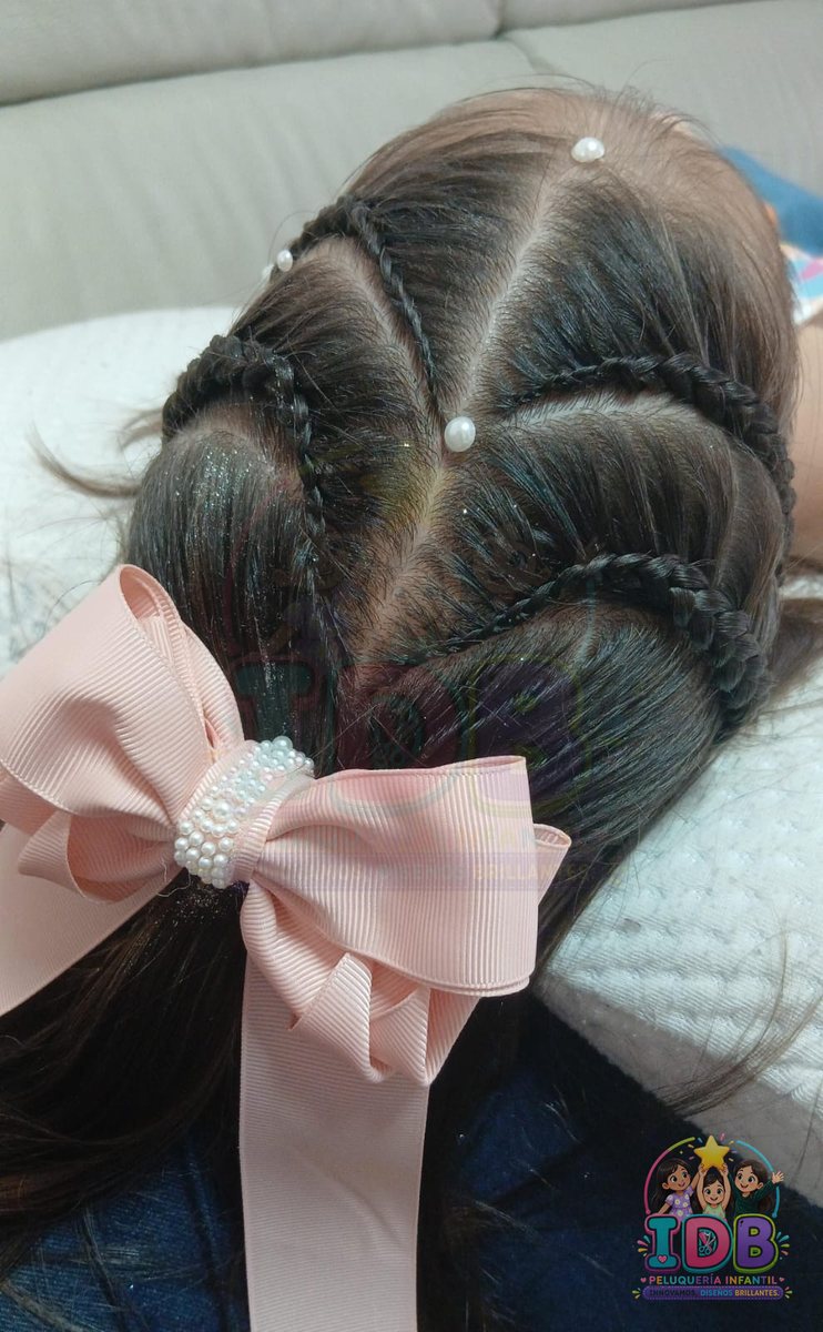 Trenzas con lazo rosa y perlas en una niña