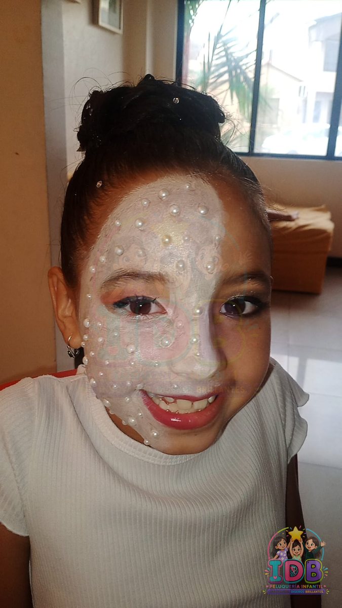 Niña con maquillaje artístico y perlas en el rostro